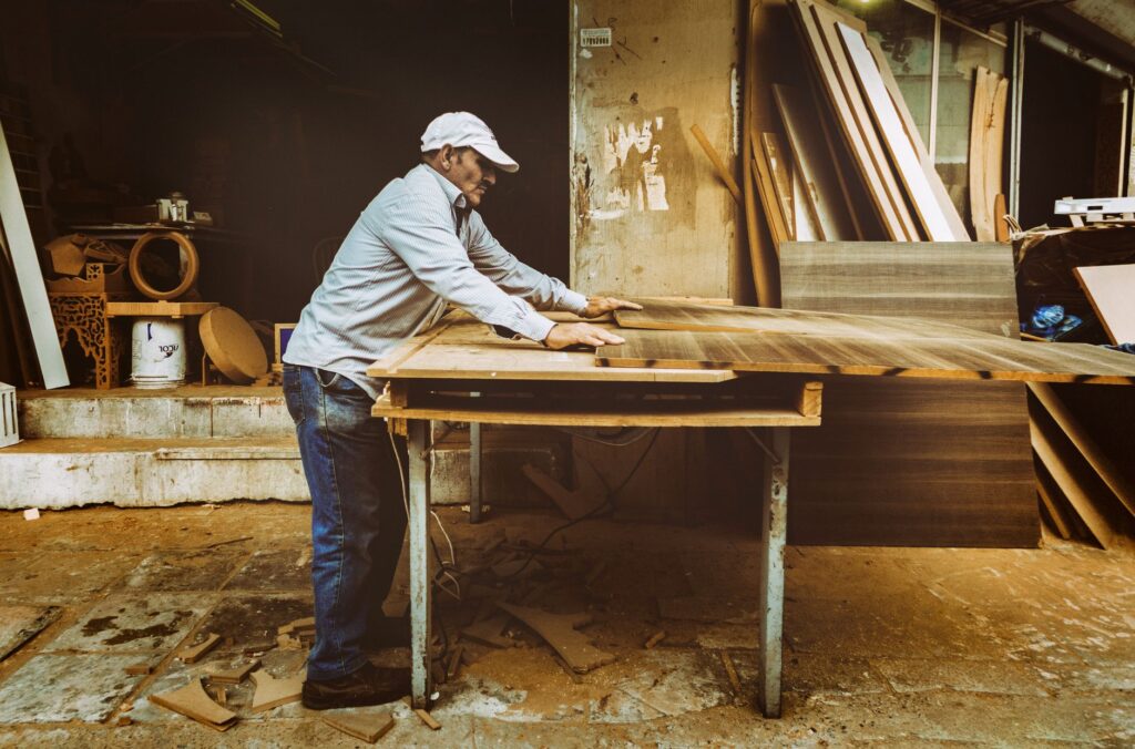 Carpenter planing a wood board in a workshop