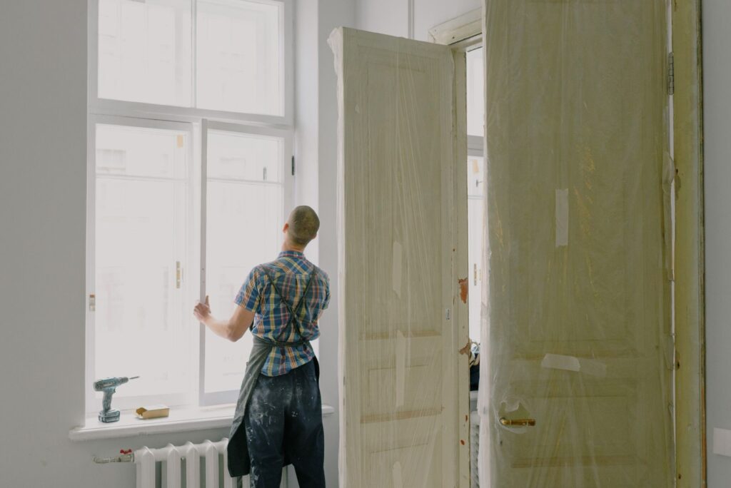 Handyman fixing a door in a bright room