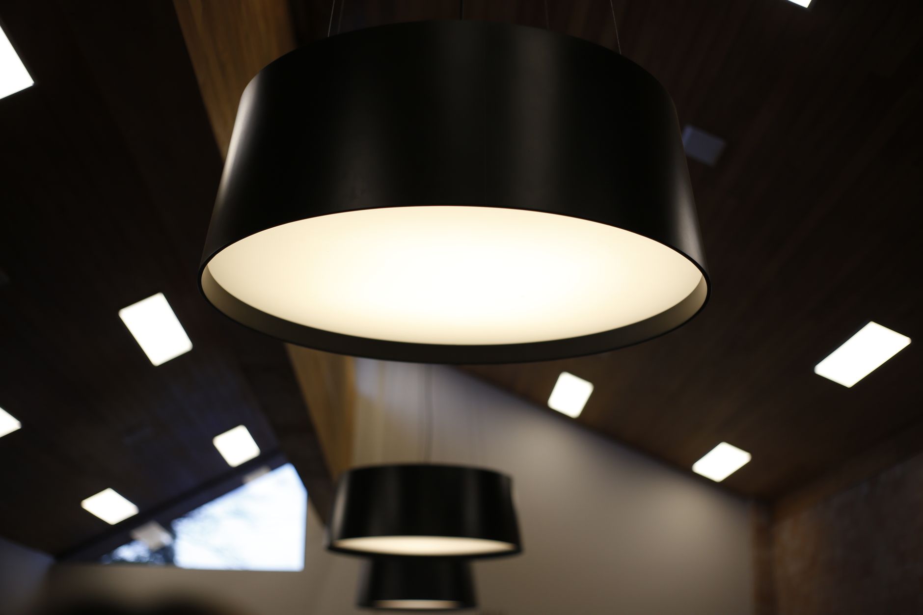 Black pendant lights over a ceiling