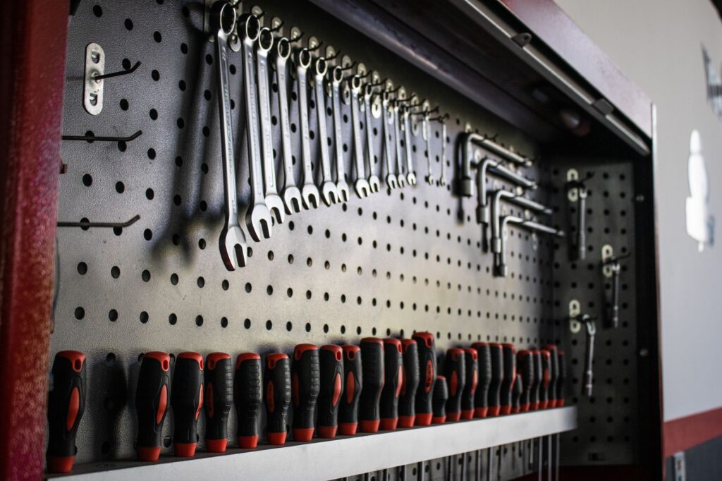 Wrenches and tools hung on a garage pegboard