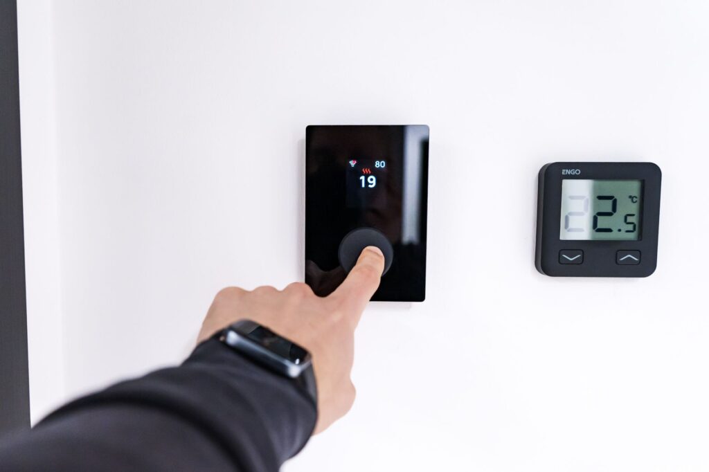 Hand setting a wall-mounted smart thermostat